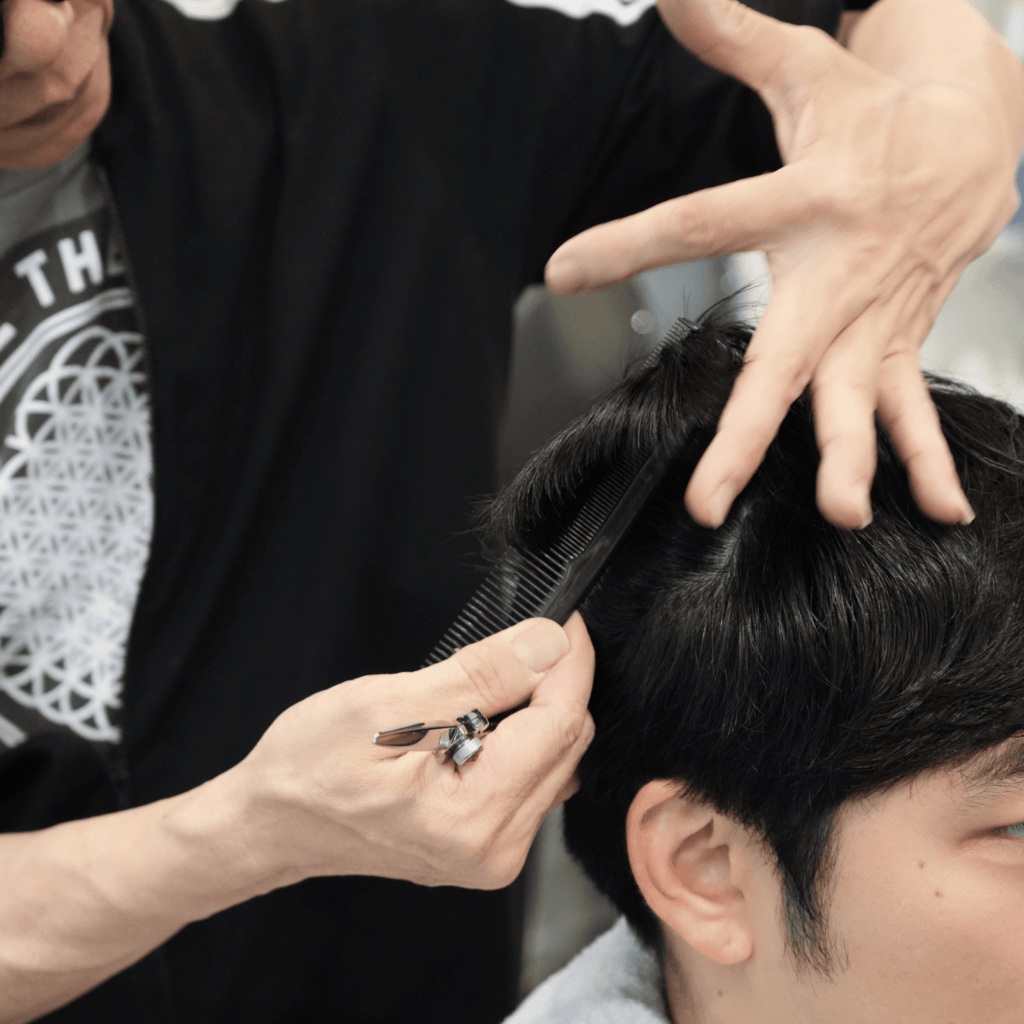 a man getting his hair cut by Kiji, the hairstylist