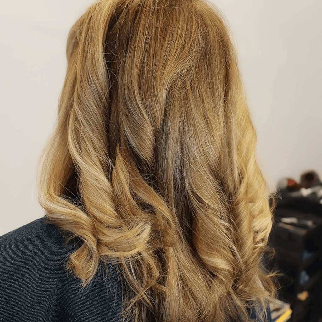 A person with gold highlights and blowout