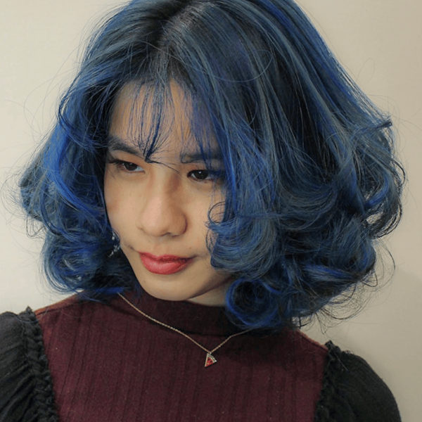 Lola, the receptionist of Wind Hair Salon, with blue highlights
