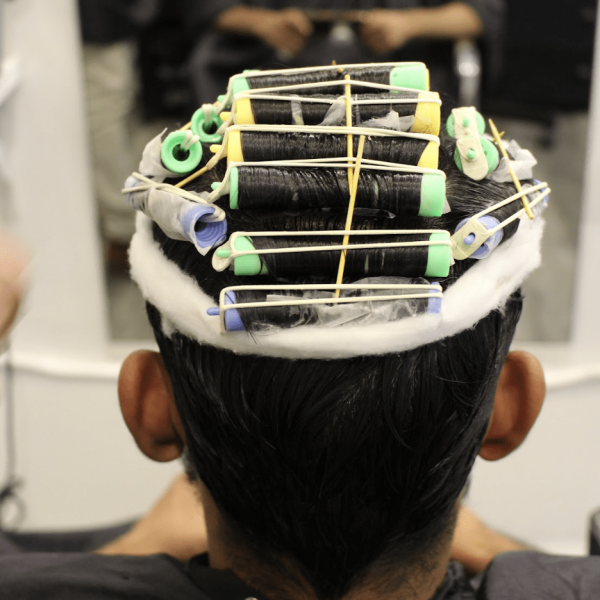 a person in the process of perming, with perm rods